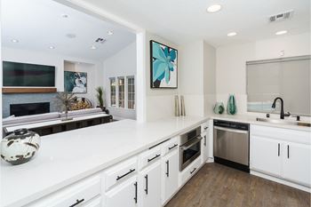 A white kitchen with a large counter top and a sink
